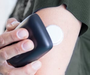 Une personne avec un scanner de surveillance du glucose