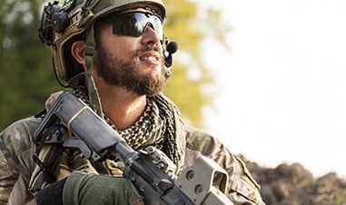Soldat im Wald mit Waffen und Kommunikationsausrüstung