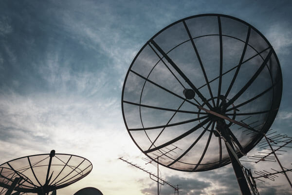 Large satellite dishes against a cloudy sky 