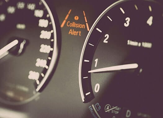 A car dashboard with an ADAS collision alert