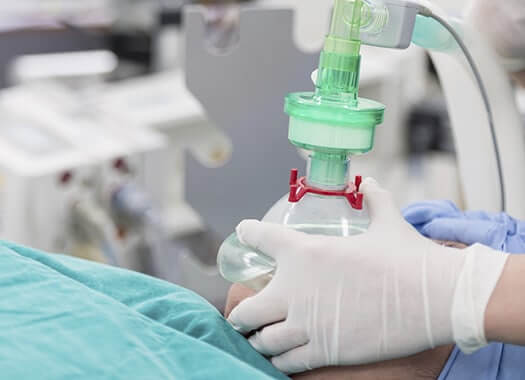 A breathing mask being placed on a patient's face