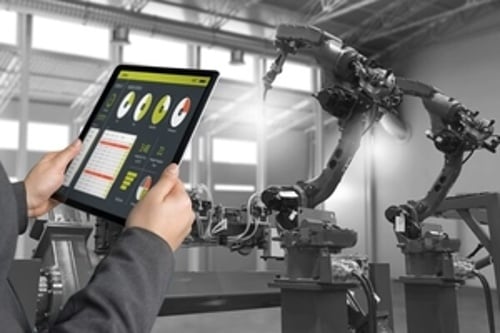 Smart Manufacturing - Man holdling tablet near robotic arms